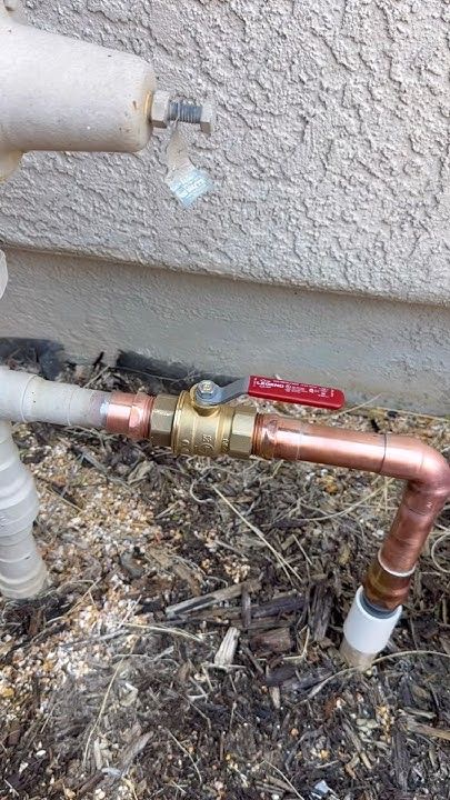 New copper pipework with isolation valve installed on an exterior wall