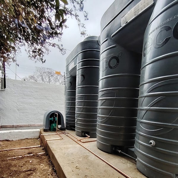Row of large Eco water tanks installed with copper pipework and pump housing