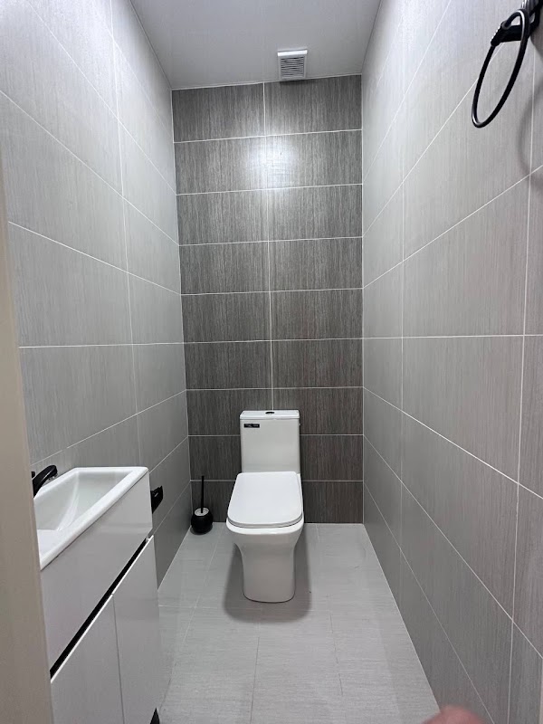 Renovated guest toilet with grey tiles, basin and modern toilet suite