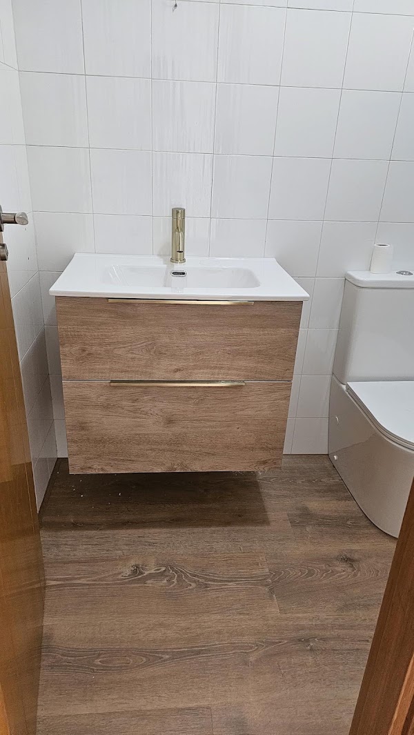 New wooden vanity unit with basin and gold mixer tap installed in a bathroom